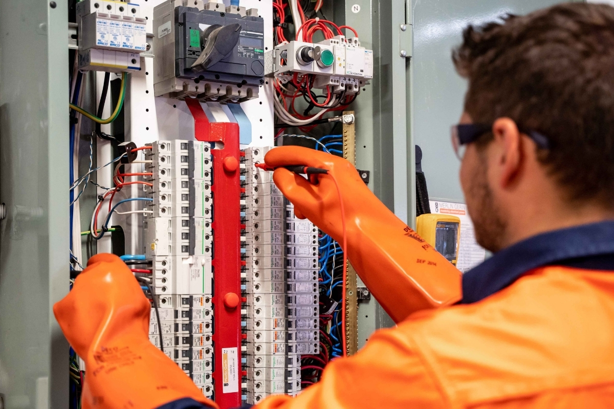 Man wearing safety gear working on electrical box